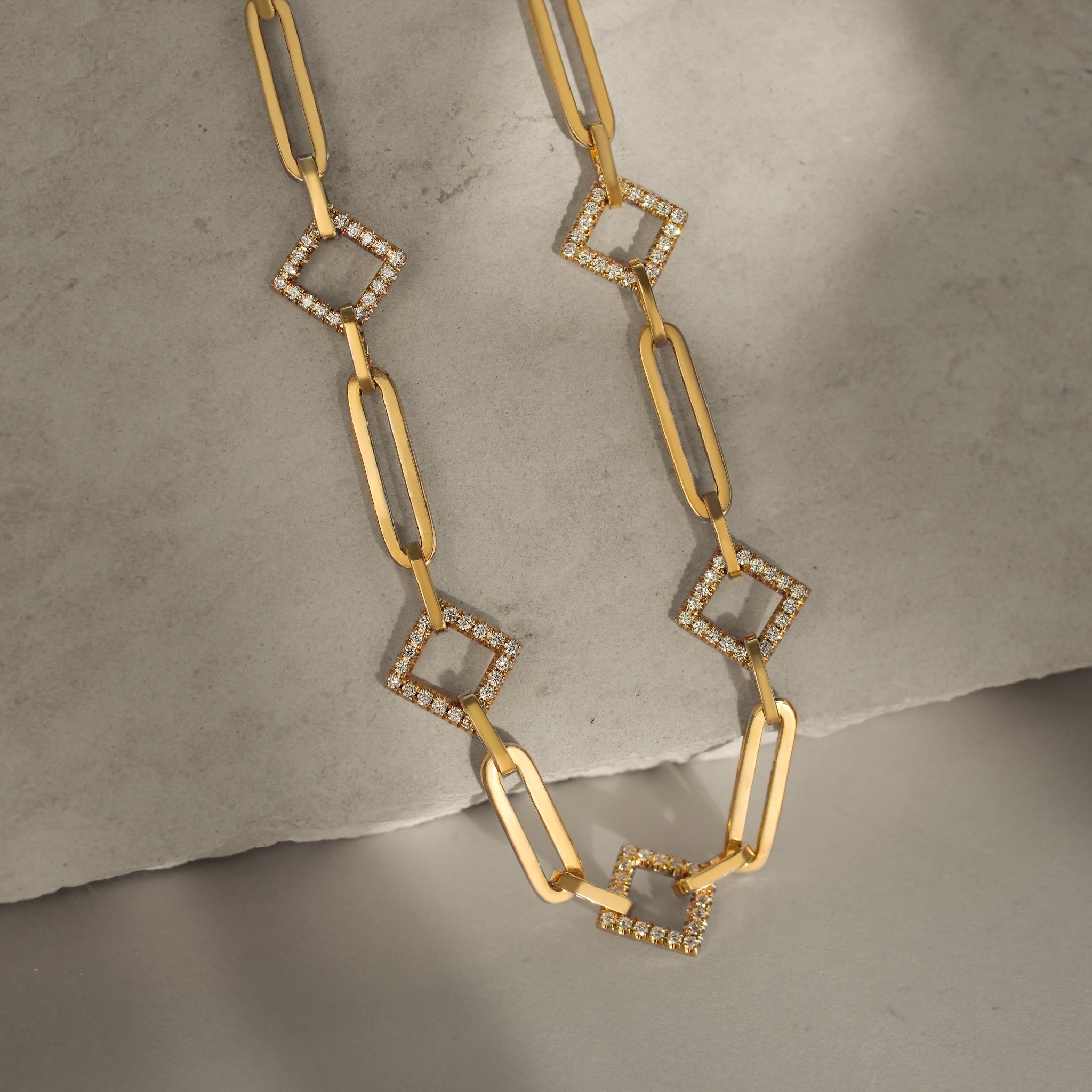 14k yellow gold chain with a mix of square links with diamonds and cable style links alternating small and large