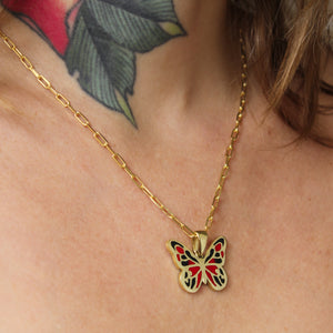 side view of female model wearing the butterfly pendant on a delicate gold chain, creating a striking and delicate look.