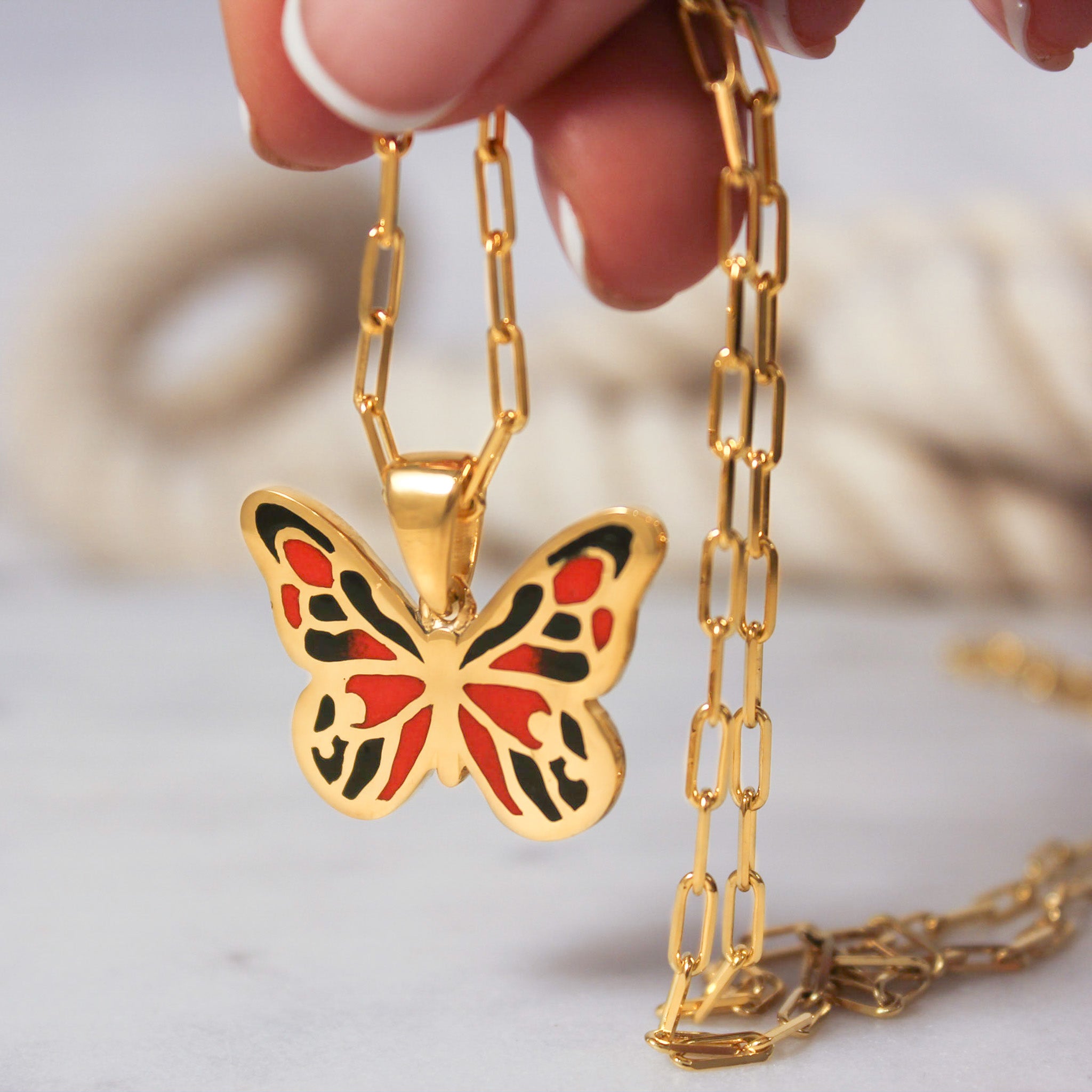 Artistic shot of the butterfly pendant against a neutral background, showcasing its stunning colors and design.