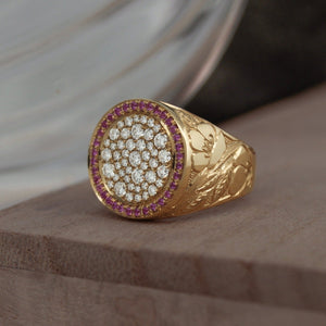14k yellow gold signet ring 34 VS diamonds of random sizes pave set on the face  with a halo of baby pink sapphires the band is high relief engraved with a pattern of wild flowers and leafs.